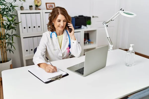 Middle Age Hispanic Woman Wearing Doctor Uniform Talking Smartphone Clinic — Stock Photo, Image