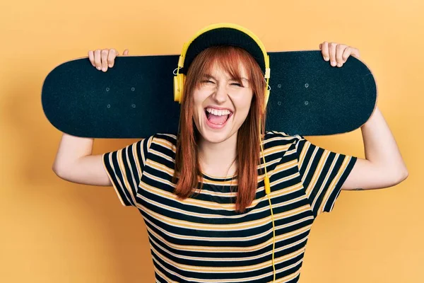 Ruiva Jovem Mulher Segurando Skate Usando Fones Ouvido Sorrindo Rindo — Fotografia de Stock