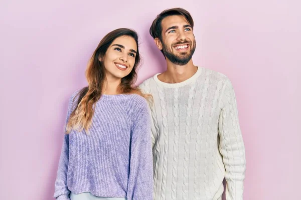 若いヒスパニック系のカップルの顔に笑顔で横に見てカジュアルな服を着て 自然な表現 自信を持って — ストック写真