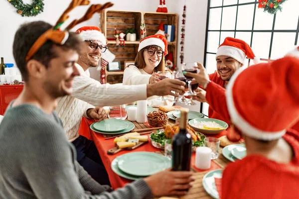 家でワインと一緒にクリスマスの乾杯を祝う幸せ笑顔の若者のグループ — ストック写真