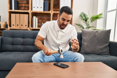 Genç İspanyol adam evde çekiçle akıllı telefonu kırdığını vurguladı.