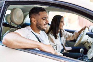 Genç İspanyol çift gülümsüyor. Şehirde mutlu araba kullanıyorlar..