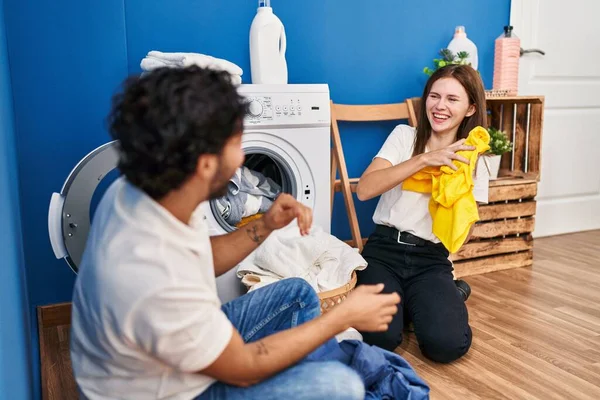 男男女女笑着自信地在洗衣房里玩耍清洁衣服 — 图库照片