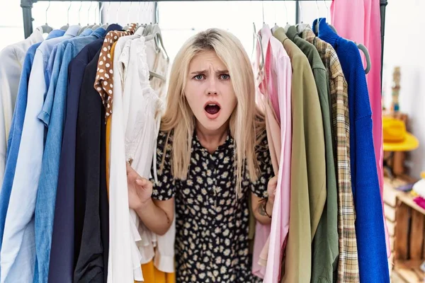 Young Blonde Woman Searching Clothes Clothing Rack Afraid Shocked Surprise — 图库照片
