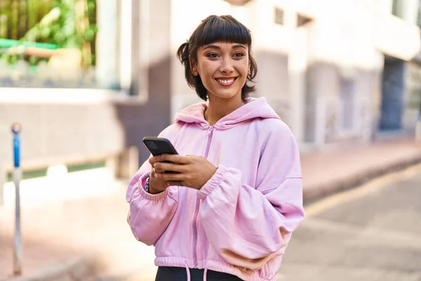 Junge Frau Lächelt Selbstbewusst Mit Smartphone Auf Der Straße — Stockfoto