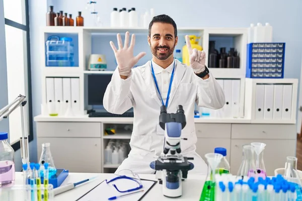 Young Hispanic Man Beard Working Scientist Laboratory Showing Pointing Fingers — Stock fotografie