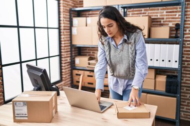 Ofiste dizüstü bilgisayar kullanan Latin kökenli genç bir iş adamı.