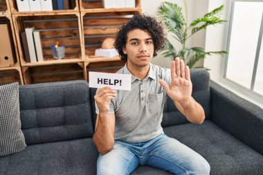 Kıvırcık saçlı İspanyol adam elini uzatıp yardım istiyor. Dur işareti yapıyor. Ciddi ve kendinden emin bir ifadeyle. 