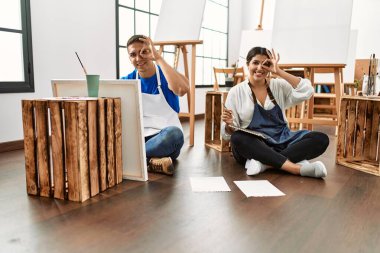 Sanat stüdyosundaki genç İspanyol çift gülümsüyor. 