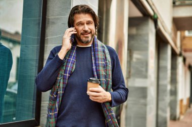 Kasabada konuşan orta yaşlı yakışıklı adam.