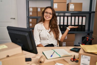 Küçük işletme şirketinde çalışan genç İspanyol kadın neşeli bir şekilde gülümsüyor ve avuç içi kameraya bakıyor.. 