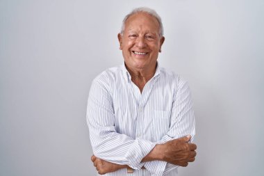 Senior man with grey hair standing over isolated background happy face smiling with crossed arms looking at the camera. positive person. 