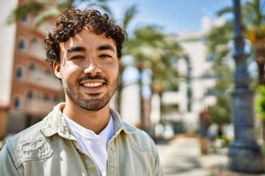 Yakışıklı, sakallı, güneşli bir günde mutlu bir şekilde gülümseyen bir İspanyol.