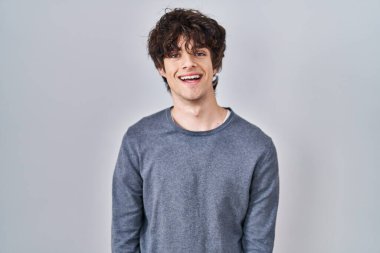 Mutlu ve havalı bir gülümsemeyle izole bir geçmişin başında duran genç bir adam. şanslı kişi. 