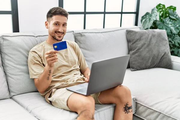 Young Hispanic Man Using Laptop Credit Card Home — Stok fotoğraf
