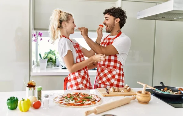 Casal Jovem Sorrindo Feliz Cozinhar Pizza Italiana Dar Comida Uns — Fotografia de Stock