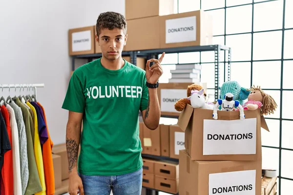 Joven Hombre Hispano Guapo Vistiendo Camiseta Voluntaria Stand Donaciones Señalando —  Fotos de Stock