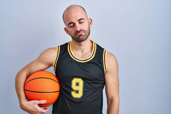 Young Bald Man Beard Wearing Basketball Uniform Holding Ball Looking — Foto de Stock