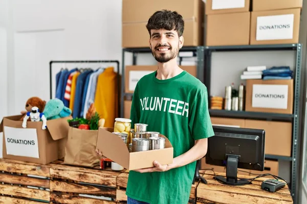 Ung Hispanic Mann Frivillig Uniform Holder Hermetikk Veldedighetssenteret – stockfoto