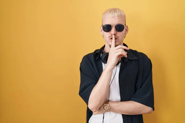 Young Caucasian Man Wearing Sunglasses Standing Yellow Background Asking Quiet — Stok fotoğraf