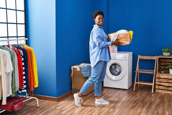 African American Woman Smiling Confident Holding Basket Clothes Laundry Room — Stockfoto