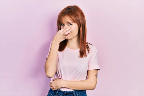 Mujer Joven Pelirroja Que Usa Una Camiseta Rosa Casual Oliendo —  Fotos de Stock