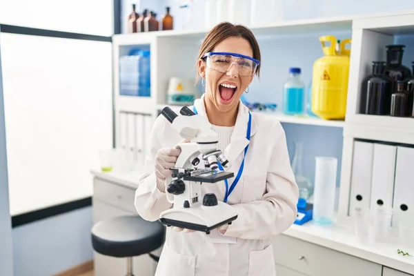 Young Brunette Woman Working Scientist Laboratory Microscope Winking Looking Camera — Photo