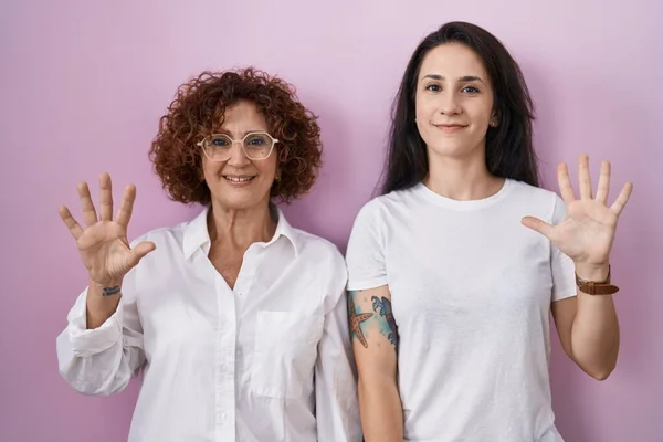 Mãe Filha Hispânica Vestindo Camiseta Branca Casual Sobre Fundo Rosa — Fotografia de Stock