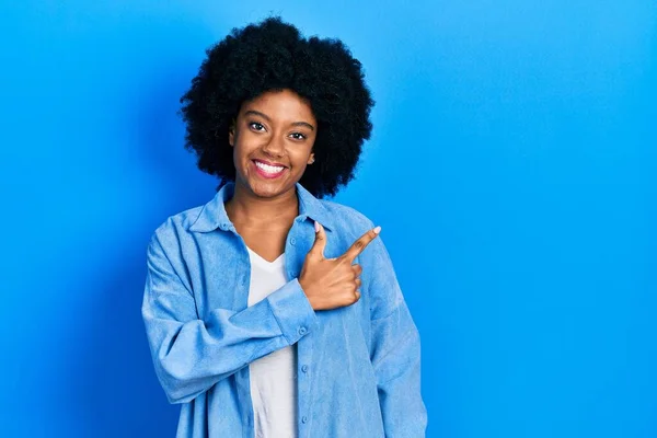 アフリカ系アメリカ人の若い女性が笑顔で陽気な服を着て 幸せと自然な表情で手と指を横に向けています — ストック写真