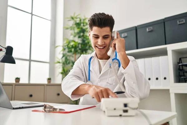 Doktor Üniforması Giyen Spanyol Genç Adam Klinikte Telefonla Konuşuyor — Stok fotoğraf
