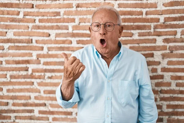 Senior Man Grey Hair Standing Bricks Wall Surprised Pointing Hand — Foto Stock