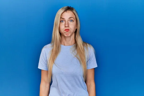 Beautiful Blonde Woman Wearing Casual Shirt Blue Background Puffing Cheeks — ストック写真