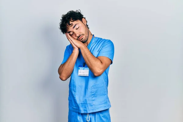 Young Hispanic Man Wearing Blue Male Nurse Uniform Sleeping Tired — Foto de Stock