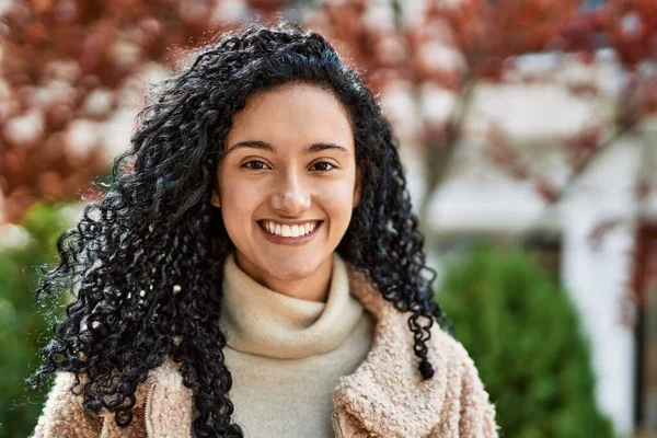 Young hispanic woman smiling confident at street