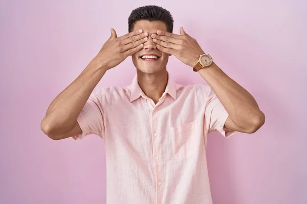 Young Hispanic Man Standing Pink Background Covering Eyes Hands Smiling — Stock fotografie