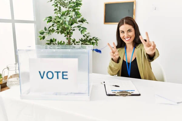 Jovem Morena Sentada Mesa Eleitoral Com Votação Sorrindo Olhando Para — Fotografia de Stock