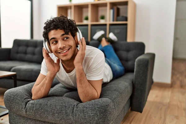 Ung Latinamerikan Lyssnar Musik Som Ligger Soffan Hemma — Stockfoto