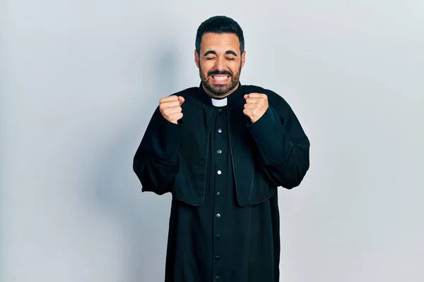 Handsome Hispanic Man Beard Wearing Catholic Priest Robe Excited Success — Stock Fotó