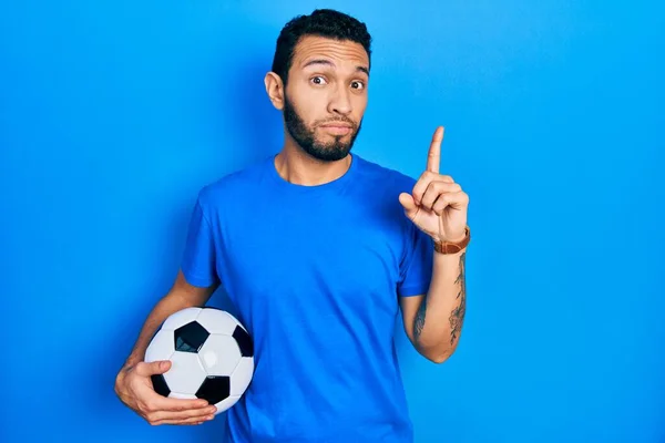 Hispanic Man Beard Holding Soccer Ball Pointing Looking Sad Upset — Fotografia de Stock
