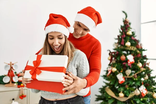 Casal Jovem Abraçando Sorrindo Feliz Usando Chapéu Natal Segurando Presente — Fotografia de Stock