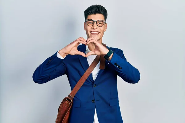 恋に笑みを浮かべてビジネス服を着て若いヒスパニック系の男性手でハートのシンボル形状を行う ロマンチックなコンセプト — ストック写真