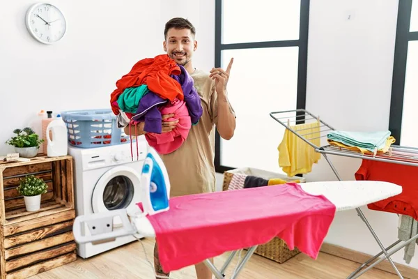 Young Handsome Man Holding Laundry Ready Iron Smiling Happy Pointing — Stock fotografie