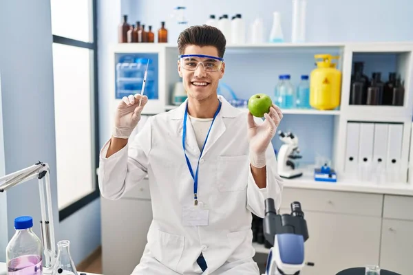 Young Hispanic Man Working Scientist Laboratory Holding Apple Smiling Happy — Fotografia de Stock