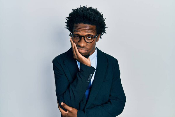 Young african american man wearing business suit thinking looking tired and bored with depression problems with crossed arms. 