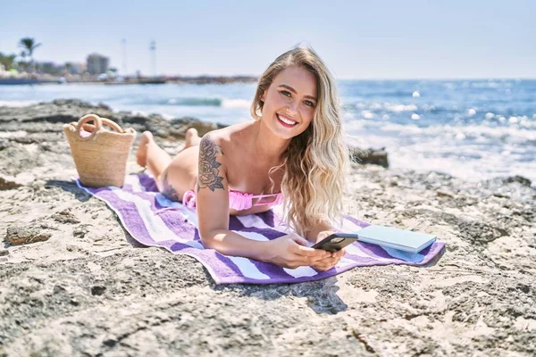 Mladá Blondýna Dívka Pomocí Smartphone Ležící Ručníku Pláži — Stock fotografie