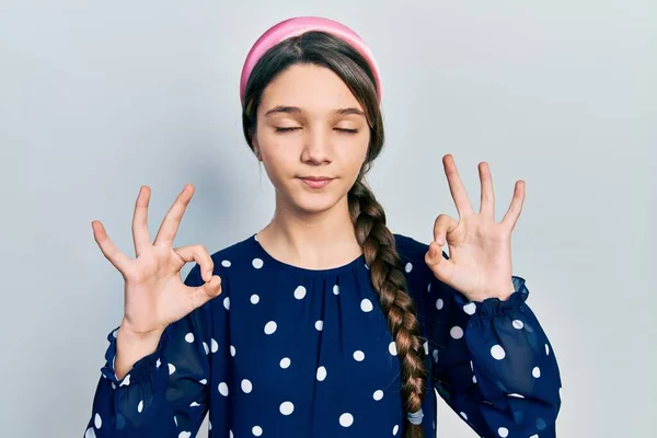 年轻的黑发女孩穿着典雅的衣服 带着微笑 闭着眼睛 用手指做冥想动作 瑜伽概念 — 图库照片