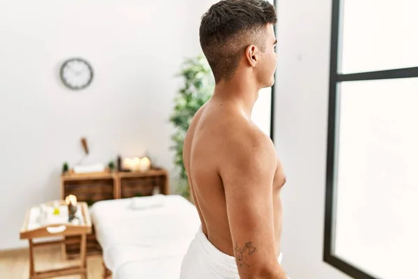 Young Hispanic Man Standing Shirtless Spa Center Looking Side Relax — Stockfoto