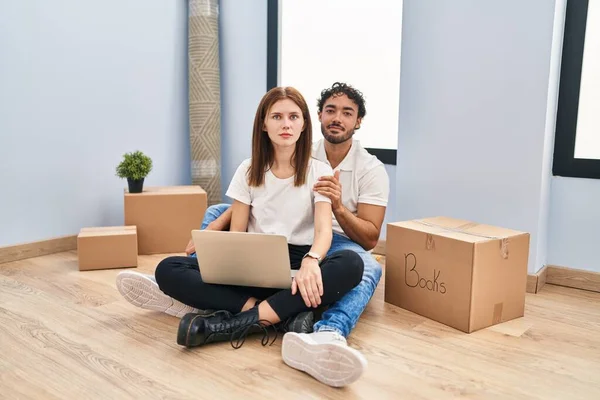 Young Couple Using Laptop New Home Relaxed Serious Expression Face — Fotografia de Stock