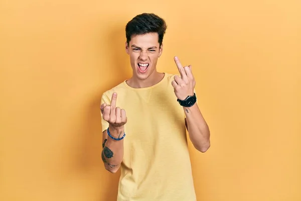 Young Hispanic Man Wearing Casual Yellow Shirt Showing Middle Finger — Stok fotoğraf
