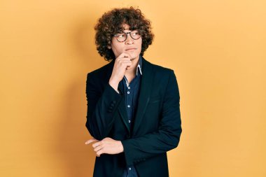 İş ceketi ve gözlük takan yakışıklı genç adam. Ciddi bir yüz ifadesi. Soru sorarken çenesi üzerine kafa karıştırıcı bir düşünce. 